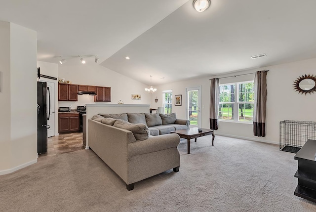 living room with light colored carpet, a chandelier, and vaulted ceiling