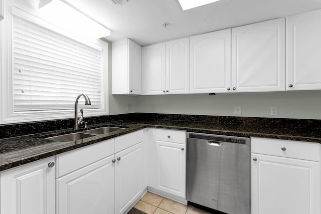 kitchen with light tile patterned flooring, dishwasher, dark stone countertops, and white cabinets