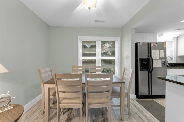 dining space with sink, ceiling fan, and light wood-type flooring