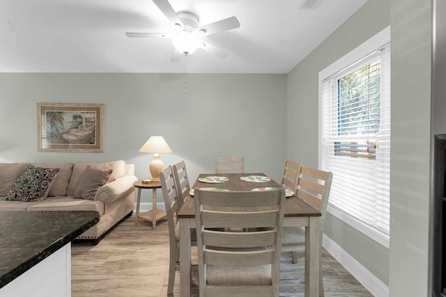 dining area with light hardwood / wood-style flooring and ceiling fan