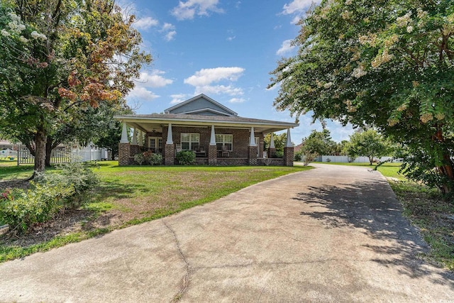 view of front facade with a front yard and covered porch