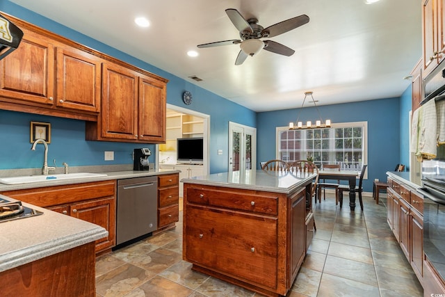 kitchen featuring sink, decorative light fixtures, dishwasher, a kitchen island, and ceiling fan with notable chandelier