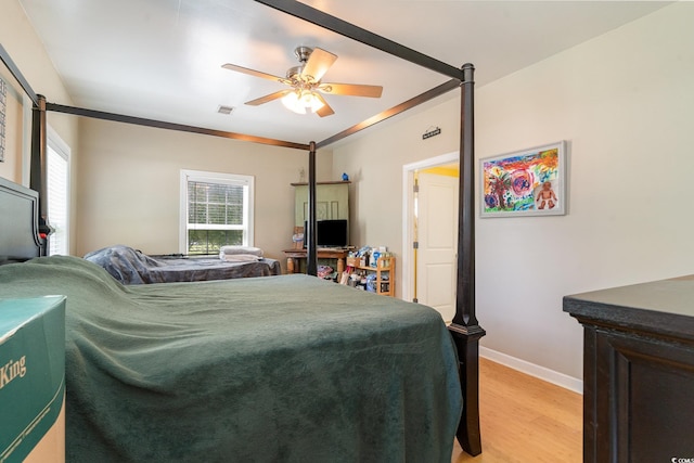 bedroom with multiple windows, ornamental molding, light wood-type flooring, and ceiling fan