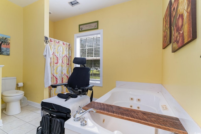 bathroom featuring a washtub, tile patterned floors, and toilet