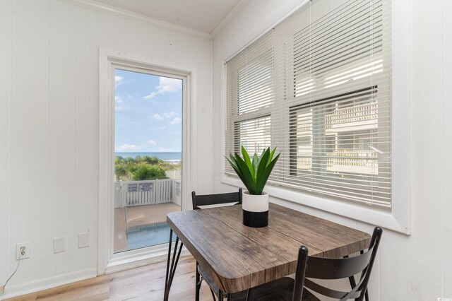 dining area with light wood-type flooring and ornamental molding