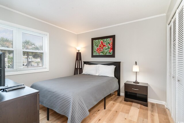 bedroom with crown molding, multiple windows, and light hardwood / wood-style flooring