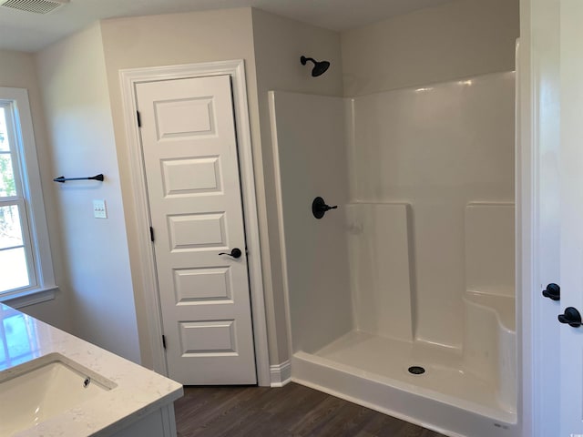 bathroom featuring vanity, hardwood / wood-style floors, and walk in shower