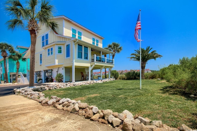 view of side of home with a balcony, covered porch, and a lawn