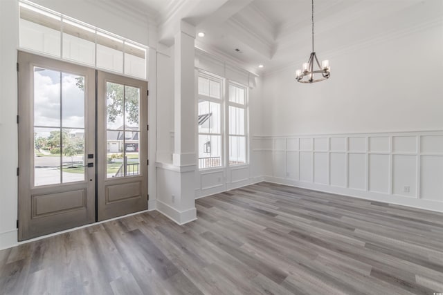 entrance foyer with crown molding, hardwood / wood-style floors, and an inviting chandelier