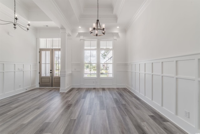 unfurnished room featuring hardwood / wood-style floors, french doors, a raised ceiling, crown molding, and a chandelier