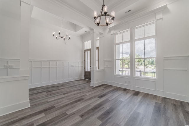 interior space featuring a notable chandelier, dark hardwood / wood-style floors, a raised ceiling, and ornamental molding