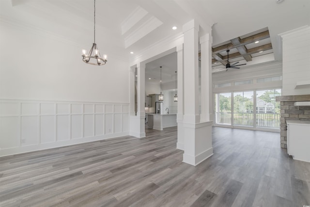 unfurnished dining area with coffered ceiling, ceiling fan with notable chandelier, crown molding, beamed ceiling, and light hardwood / wood-style floors