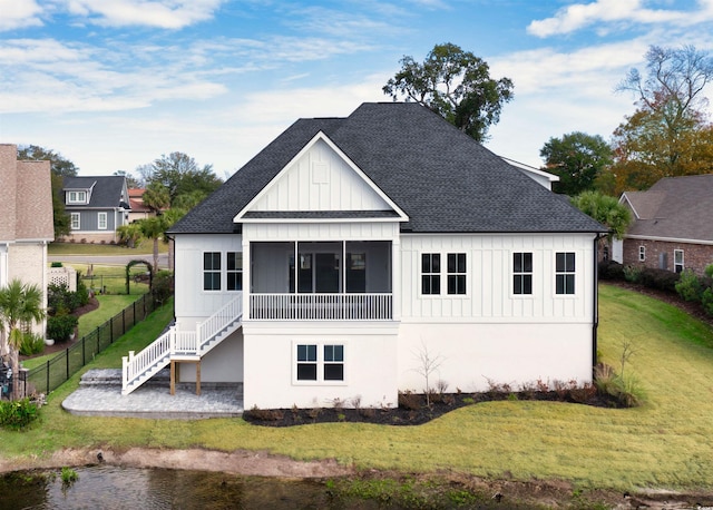 rear view of property featuring a sunroom and a yard