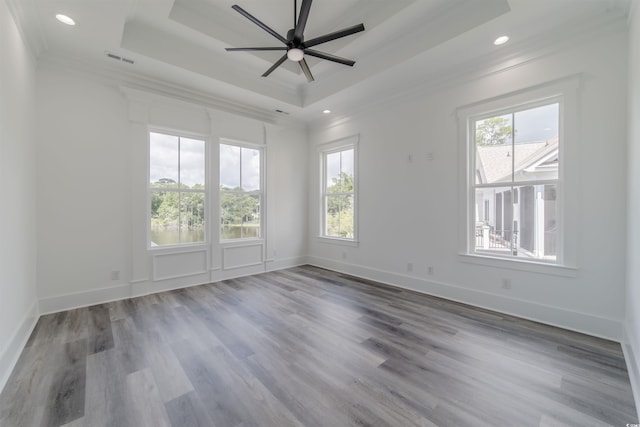 spare room with a wealth of natural light, ceiling fan, wood-type flooring, and ornamental molding