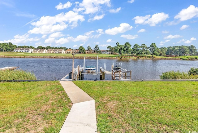 view of dock with a yard and a water view