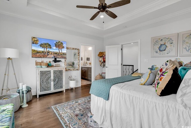 bedroom with ornamental molding, dark wood-type flooring, and a tray ceiling