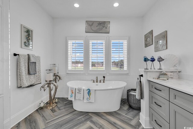 bathroom featuring vanity, a tub, and tile walls