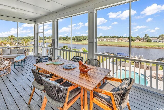 sunroom / solarium featuring a water view