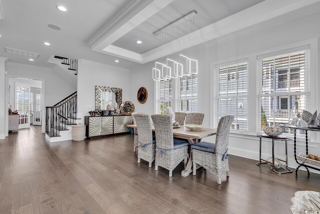 dining space featuring ornamental molding, dark hardwood / wood-style flooring, a raised ceiling, and a notable chandelier