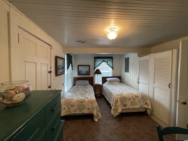 bedroom featuring a closet, visible vents, wooden ceiling, and dark colored carpet
