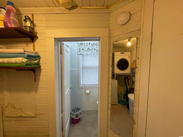 interior space with wood ceiling and stacked washing maching and dryer