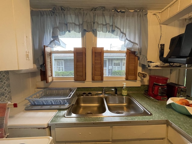 kitchen featuring a sink, white cabinets, and a wealth of natural light