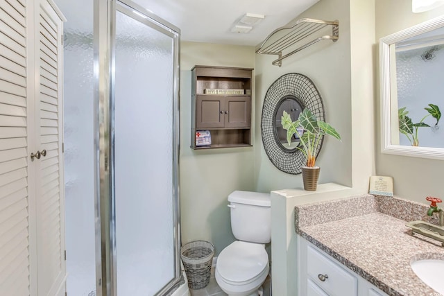 bathroom with vanity, toilet, and a shower with shower door