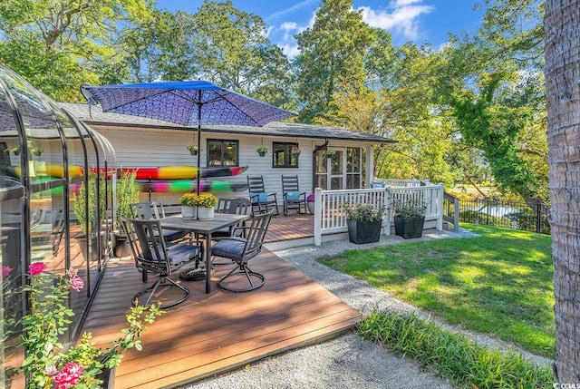 deck featuring a sunroom and a lawn