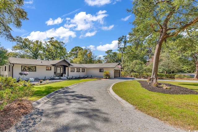 ranch-style home featuring a front lawn and a garage