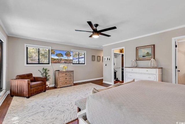 bedroom featuring a closet, light wood-type flooring, crown molding, a walk in closet, and ceiling fan