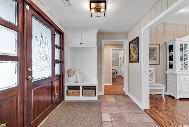 mudroom featuring crown molding and light tile patterned flooring