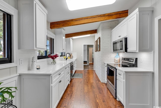 kitchen featuring stainless steel appliances, white cabinets, sink, and hardwood / wood-style flooring