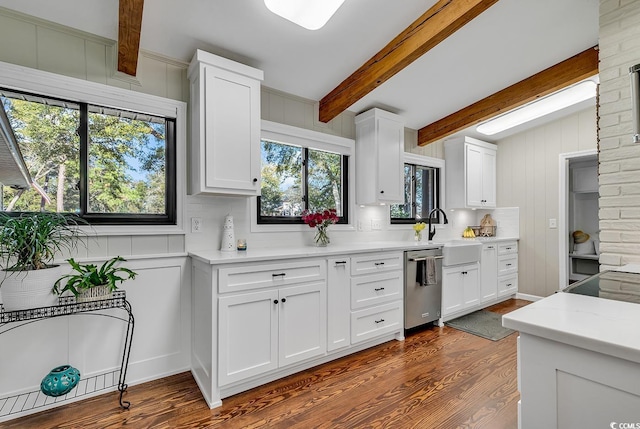 kitchen featuring sink, white cabinets, dishwasher, and beamed ceiling