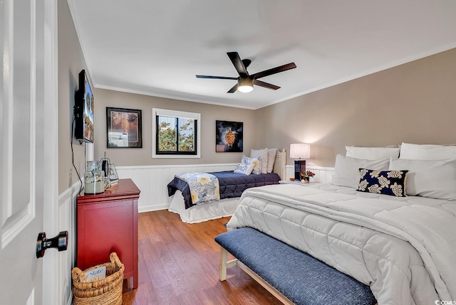 bedroom with wood-type flooring, ceiling fan, and ornamental molding