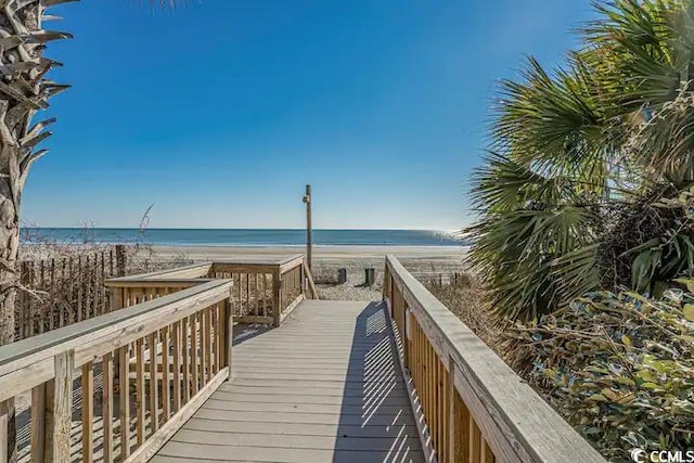 surrounding community with a beach view and a water view