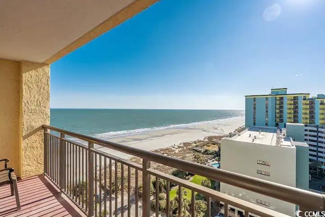 balcony with a water view and a view of the beach