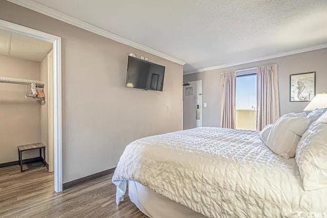 bedroom featuring a textured ceiling, crown molding, hardwood / wood-style floors, and a closet