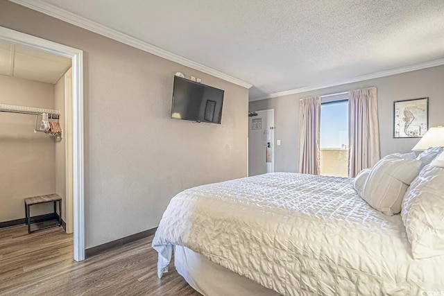 bedroom featuring crown molding, hardwood / wood-style flooring, a textured ceiling, and a closet