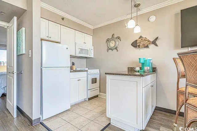 kitchen with white appliances, crown molding, hanging light fixtures, light hardwood / wood-style floors, and white cabinetry