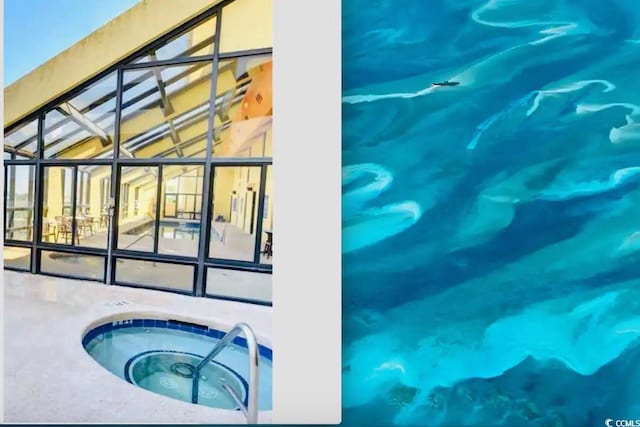 view of swimming pool with a lanai and an indoor hot tub