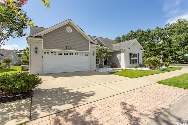 view of front facade featuring a front yard, central AC, and a garage