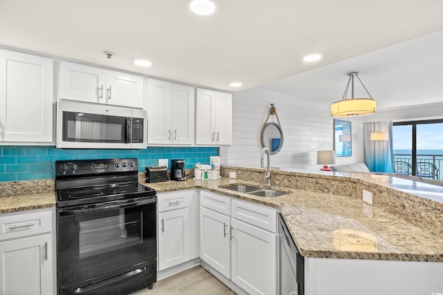 kitchen with appliances with stainless steel finishes, decorative light fixtures, sink, white cabinets, and kitchen peninsula