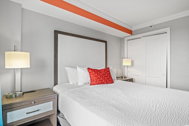 bedroom featuring crown molding and a closet