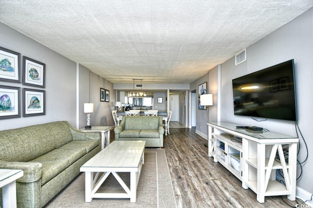 living room featuring wood-type flooring and a textured ceiling