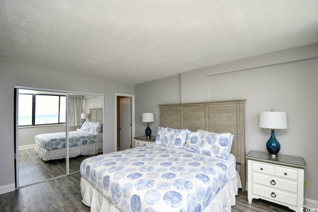 bedroom with dark hardwood / wood-style floors, a textured ceiling, and a closet