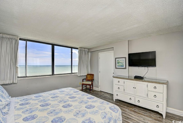 bedroom featuring dark hardwood / wood-style flooring and a textured ceiling