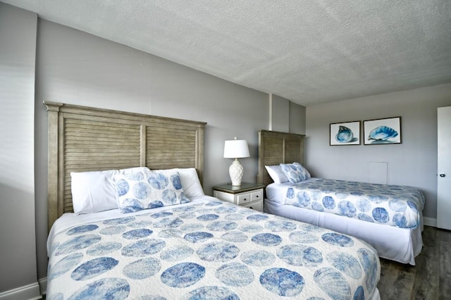 bedroom with dark wood-type flooring and a textured ceiling