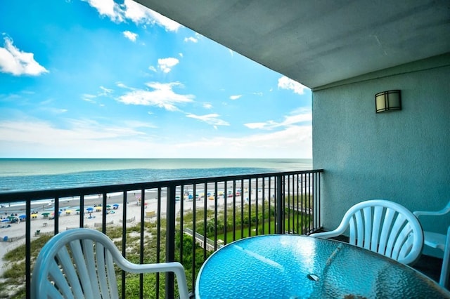 balcony featuring a water view and a view of the beach