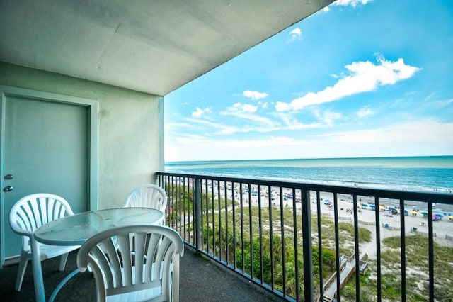 balcony with a water view and a view of the beach