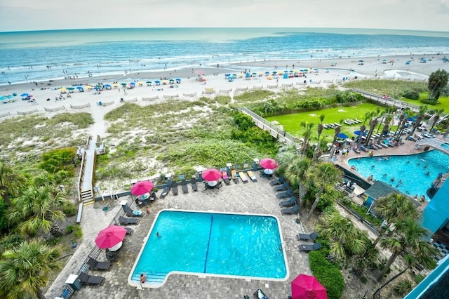 drone / aerial view featuring a water view and a beach view